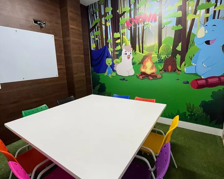 Sala da turma kids em Brás Cubas, com cadeiras coloridas e os personagens do livro na parede
