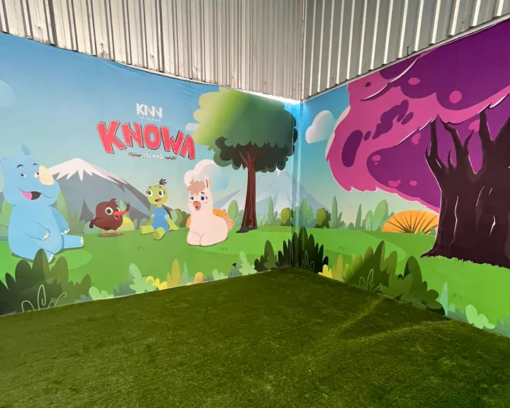 Espaço kids coberto em Brás Cubas, com mural dos personagens e grama sintética