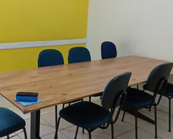 Sala de aula no Centro, com mesa única e cadeiras em volta