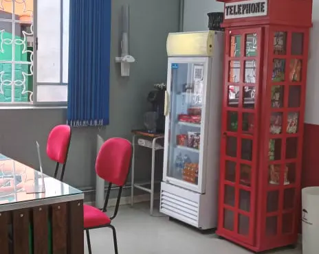 Cantinho do café no Centro, com geladeira e cabine telefônica vermelha