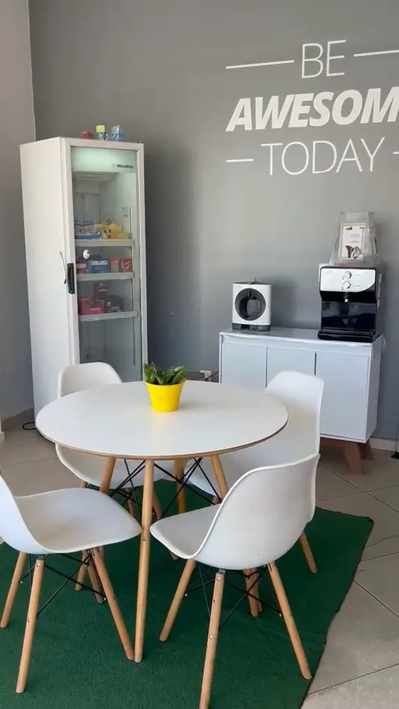 Café de César de Souza, com mesa redonda e a frase Be Awesome Today na parede