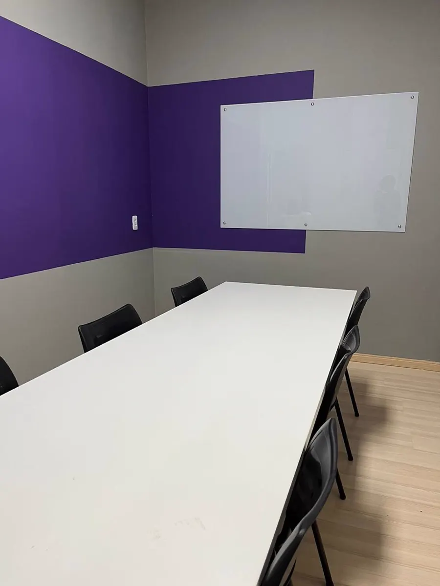 Sala de aula da KNN em Brás Cubas, com mesa única e cadeiras em volta